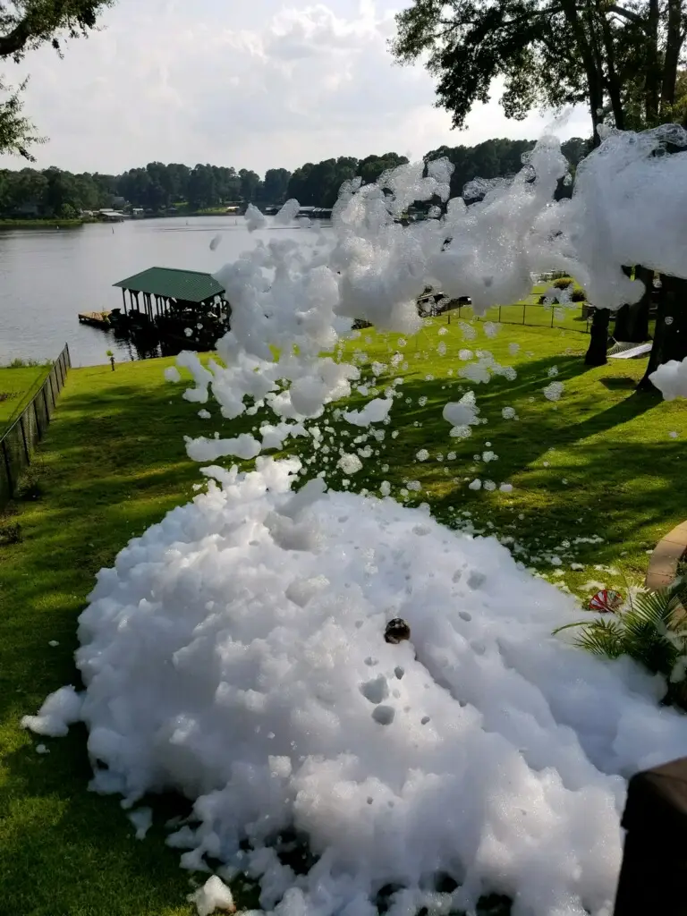 Foam pile being shot into pile in yard in front of lake